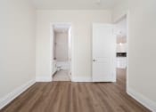Thumbnail 8 of 40 - a bedroom with white walls and hardwood floors