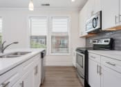 Thumbnail 17 of 40 - a kitchen with white cabinets and stainless steel appliances