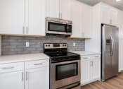 Thumbnail 16 of 40 - a kitchen with white cabinets and stainless steel appliances
