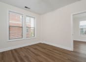 Thumbnail 20 of 40 - a bedroom with hardwood floors and two windows