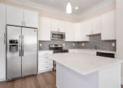 Thumbnail 2 of 40 - a kitchen with white cabinets and stainless steel appliances