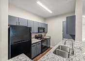 Thumbnail 1 of 42 - A kitchen with granite countertops and stainless steel appliances.