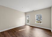 Thumbnail 5 of 42 - A room with a wooden floor and a window with a picture of a house on it.