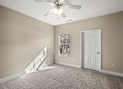 Thumbnail 4 of 42 - A room with a fan, carpet, and a door.