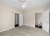 Thumbnail 7 of 42 - A room with a ceiling fan and a toilet in the corner.
