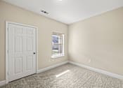 Thumbnail 6 of 42 - A room with a white door and a window with a view of a building outside.