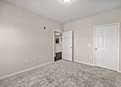 Thumbnail 19 of 42 - A room with a carpeted floor and two white doors.