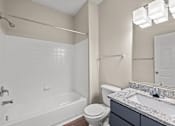 Thumbnail 21 of 42 - A white bathroom with a toilet, sink, and bathtub.