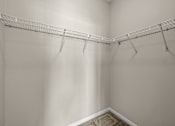 Thumbnail 23 of 42 - A white closet with a metal rack.