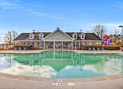 Thumbnail 32 of 42 - A large swimming pool in front of a building with a playground in the background.