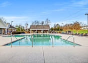 Thumbnail 33 of 42 - A large swimming pool with a diving board in the middle of a residential area.