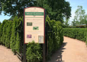 Thumbnail 35 of 38 - a sign for the maze garden in front of a row of hedges