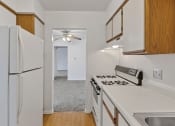 Thumbnail 17 of 38 - a kitchen with white countertops and a white refrigerator