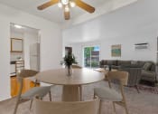 Thumbnail 12 of 38 - a living room with a ceiling fan and a dining table with four chairs