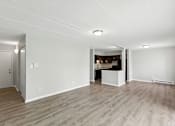 Thumbnail 2 of 45 - A spacious room with wooden flooring and white walls.