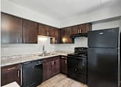 Thumbnail 1 of 45 - A kitchen with black appliances and wooden cabinets.