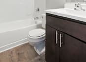 Thumbnail 4 of 45 - A white toilet sits in a bathroom next to a sink.