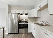 Thumbnail 19 of 45 - A modern kitchen with a stainless steel refrigerator and oven.