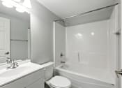 Thumbnail 21 of 45 - A white bathroom with a toilet, sink, and bathtub.