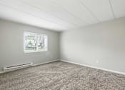 Thumbnail 22 of 45 - A room with a window and a carpeted floor.