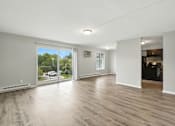 Thumbnail 25 of 45 - A spacious room with wooden flooring and sliding glass doors.