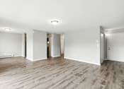 Thumbnail 26 of 45 - A spacious room with wooden flooring and white walls.