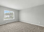 Thumbnail 31 of 45 - A room with a carpeted floor and a window overlooking a parking lot.