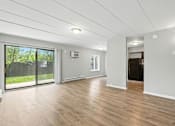 Thumbnail 39 of 45 - A spacious room with wooden flooring and white walls.
