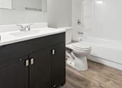 Thumbnail 40 of 45 - A white sink is on a black countertop in a bathroom.