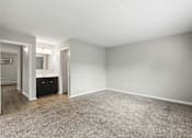 Thumbnail 42 of 45 - A spacious room with a carpeted floor and white walls.