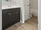 Thumbnail 45 of 45 - A bathroom with a white sink and black cabinets.