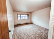 Thumbnail 22 of 29 - A room with a carpeted floor and a window with blinds.