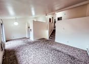 Thumbnail 18 of 29 - A large empty room with a staircase and a fire extinguisher.