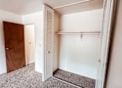 Thumbnail 20 of 29 - A white closet with a brown door is open.