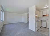 Thumbnail 4 of 29 - the spacious living room and kitchen with white cabinets and white appliances