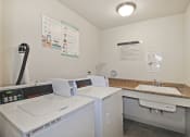 Thumbnail 24 of 29 - a laundry room with two washing machines and a sink