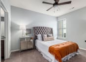 Thumbnail 4 of 23 - a bedroom with a bed and a ceiling fan