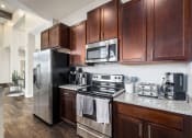 Thumbnail 2 of 23 - a kitchen with stainless steel appliances and wooden cabinets