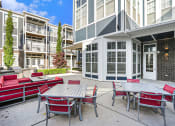 Thumbnail 9 of 27 - an outdoor patio with tables and chairs at an apartment building