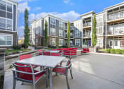 Thumbnail 10 of 27 - an outdoor patio with tables and chairs in front of an apartment building