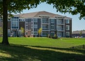 Thumbnail 14 of 27 - a large apartment building on a green lawn