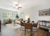 Thumbnail 18 of 27 - a living room with a dining table and a ceiling fan