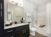 Thumbnail 24 of 27 - a bathroom with a shower toilet and sink and a mirror