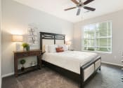 Thumbnail 26 of 27 - a bedroom with a bed and a ceiling fan