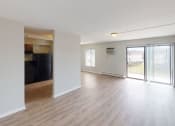 Thumbnail 42 of 46 - an empty living room with a sliding glass door to a balcony