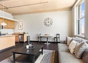 Thumbnail 16 of 29 - a living room with a couch and a clock on the wall
