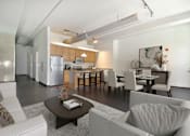 Thumbnail 10 of 29 - a living room with a couch and a table and a kitchen
