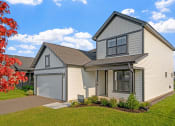Thumbnail 9 of 10 - a white and gray house with a garage and a lawn