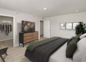 Thumbnail 4 of 8 - A bedroom with a bed, dresser, and a wall with pictures.