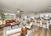 Thumbnail 8 of 32 - A modern living room with a brown leather couch and a wooden coffee table.